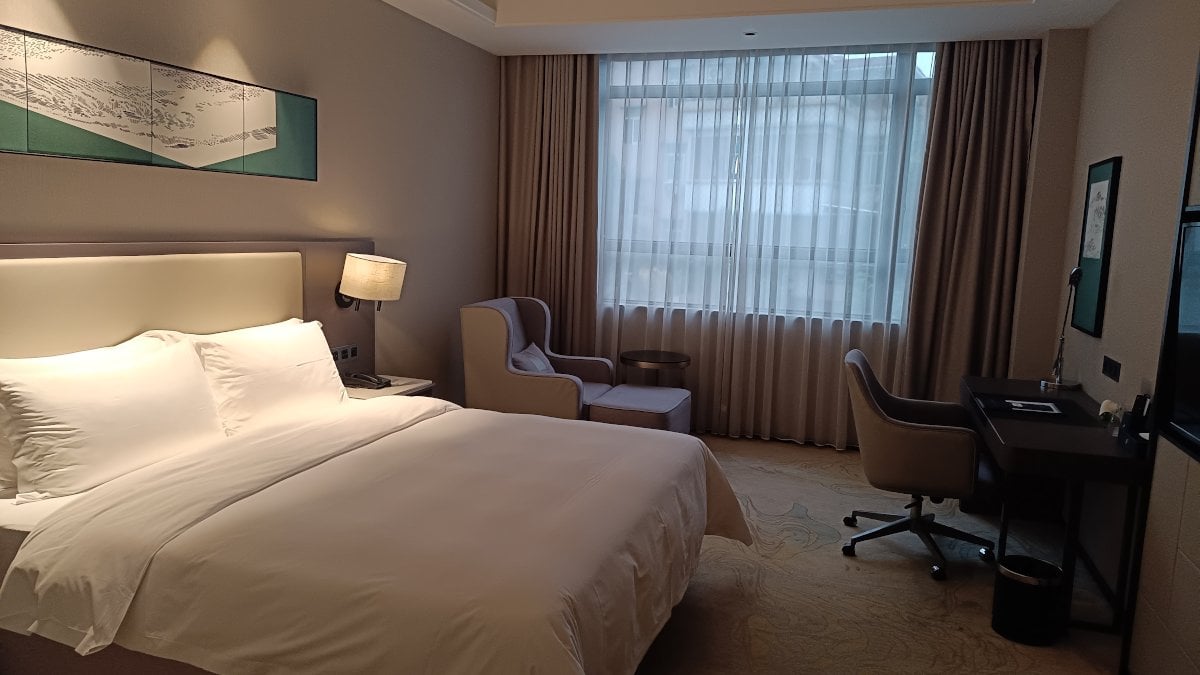 Hotelkamer van China Southern: comfortabel bed, relaxte stoel, bureau en meer